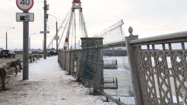 Фото: Водителю, снесшему забор на Октябрьском мосту и едва не упавшему с него, придется заплатить за ограждение